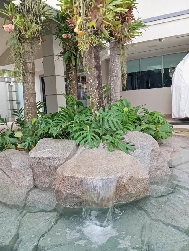 Cascata em ilha de pedra artificial com palmeiras